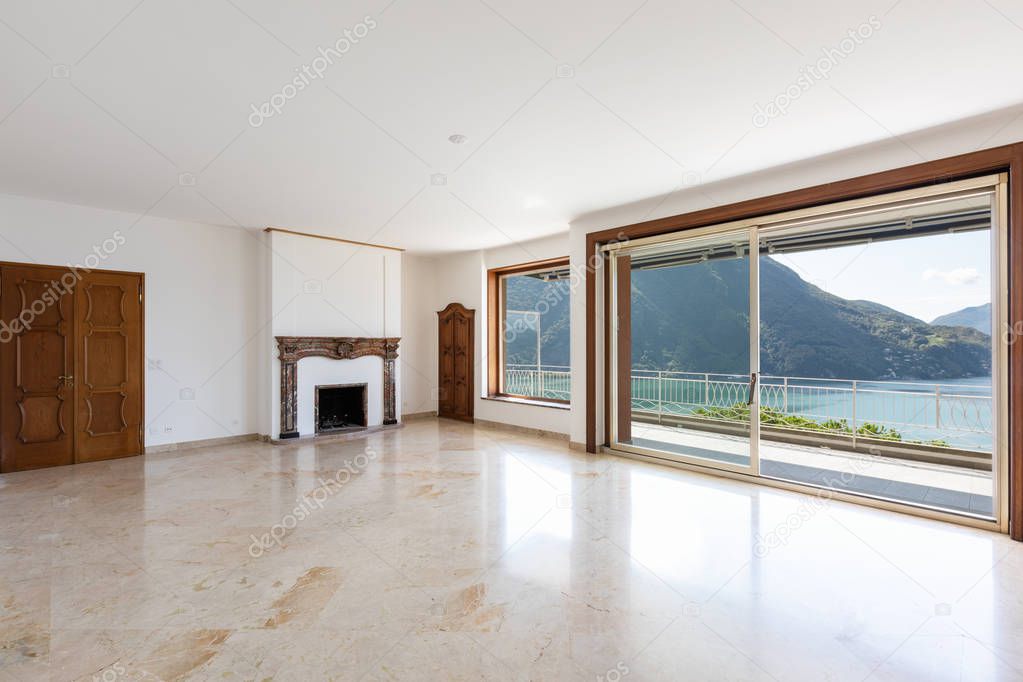 Empty living room with large windows overlooking the lake. Nobody inside