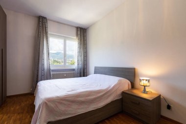 Parke ve pencere görünümü ile yatak odası. İçeride kimse yok