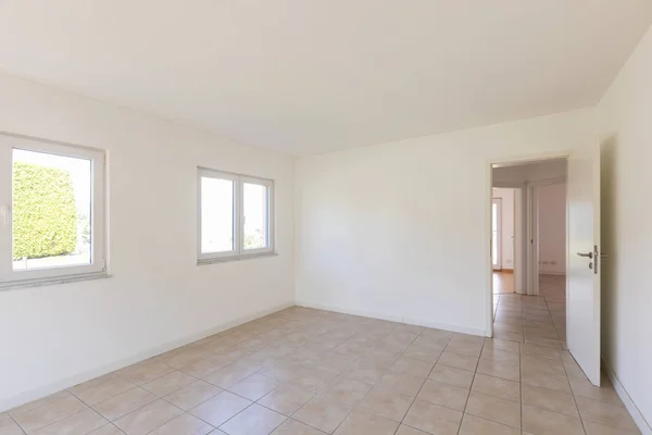 White empty room with tiles and windows, nobody inside