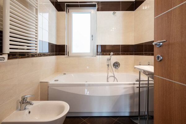 Front view bathroom with brown tiles, modern. Nobody inside