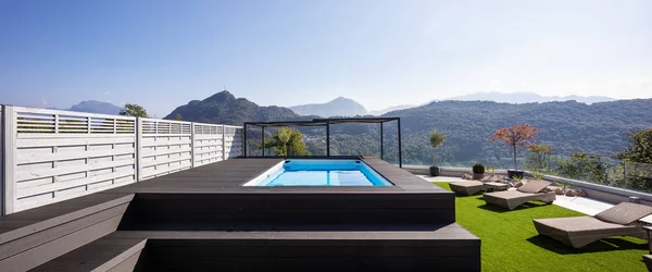 Giant balcony of modern apartment with swimming pool on a summer day. Nobody inside