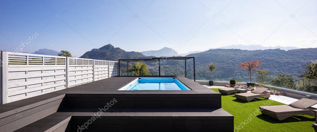Giant balcony of modern apartment with swimming pool on a summer day. Nobody inside
