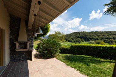 Yeşil doğa ile çevrili bir modern Villa şömineli veranda