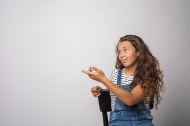 Çizgili yelek izole oturma portre kız. Kopya alanı