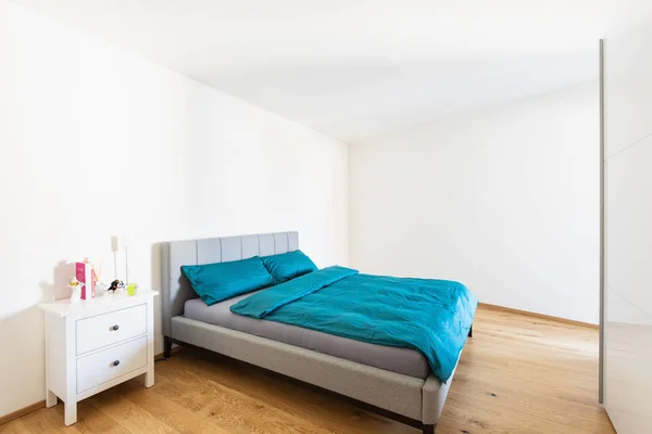 现代化的卧室配有绿松石盖和镶木地板 里面没有人 — 图库照片