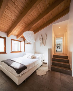 Ahşap kirişler ile yatak odası. İçeride kimse yok