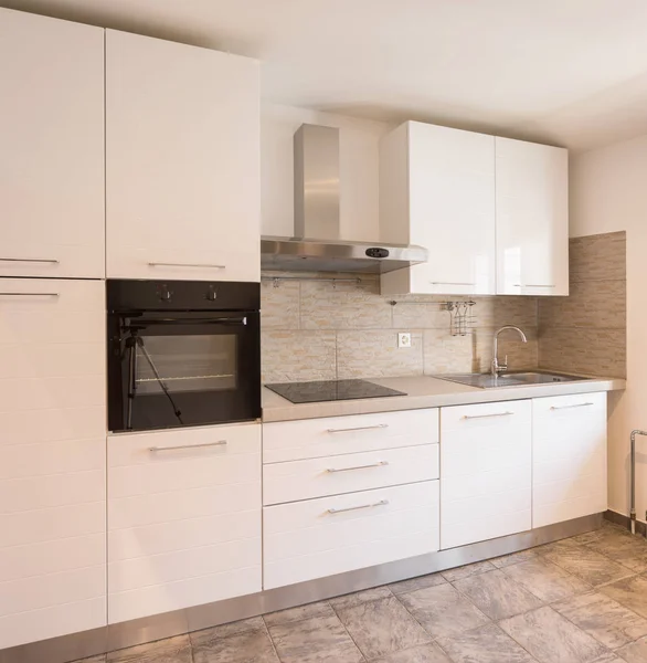 White kitchen with black oven and tiles, nobody inside