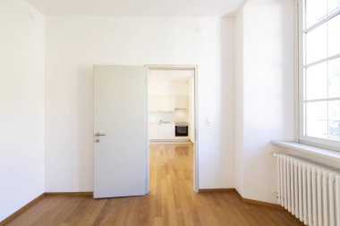 Boş oda parke ve beyaz duvarlı. İçeride kimse yok