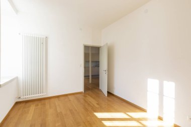 Boş oda parke ve beyaz duvarlı. İçeride kimse yok