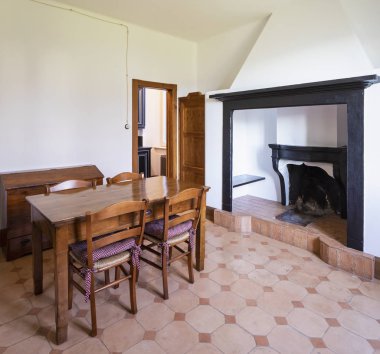 Yemek odası masa, ahşap sandalye ve bir taş şömine. İçeride kimse yok