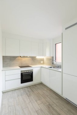 Siyah fırın ve lavabo beyaz mutfak. İçeride kimse yok