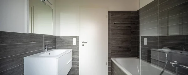 Bathroom with elegant minimalist brown tiles. Nobody inside