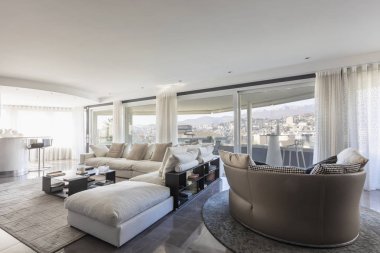 Beyaz deri kanepe ve İsviçre Lugano şehir bakan pencereler ile oturma odası. İçeride kimse yok