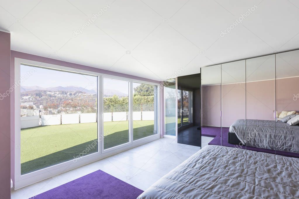 Bedroom overlooking the terrace with grass. Violet walls. Nobody inside