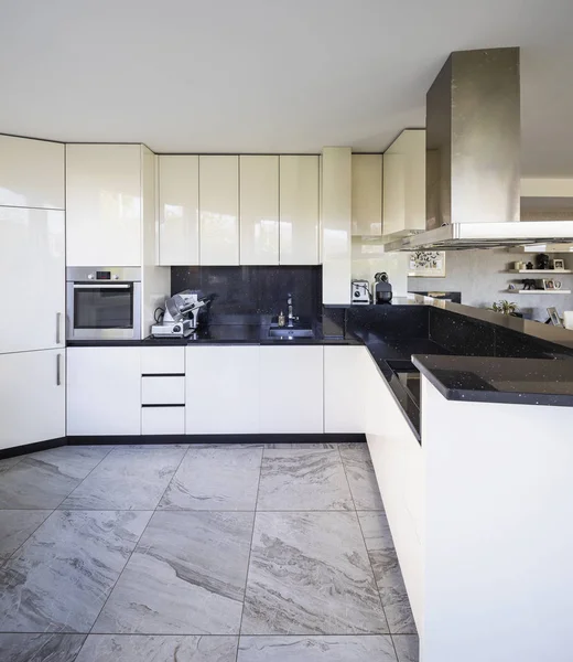 黒大理石トップと大きなフード付きの白いキッチン 誰も内部 — ストック写真