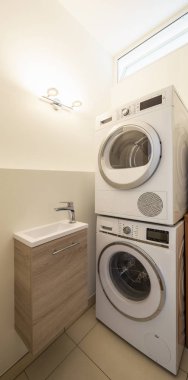 Çamaşır makinesi, kurutma makinesi çamaşır ve lavabo. İçeride kimse yok