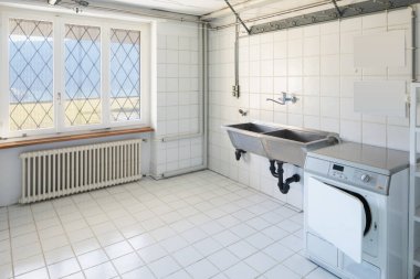 Çamaşırhane Çamaşır makinesi, beyaz çini ve göl manzaralı. İçeride kimse yok