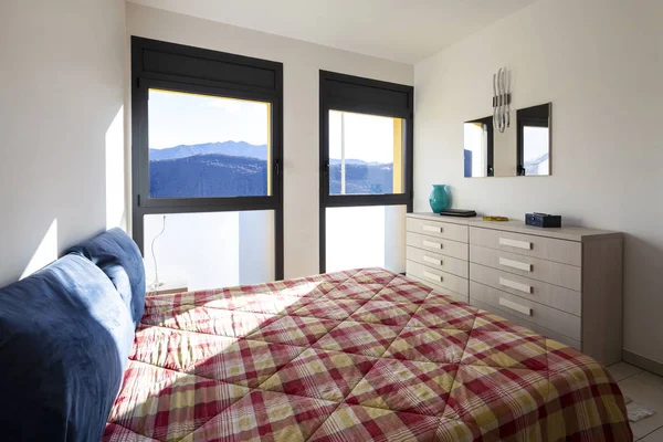 Bright bedroom with window overlooking the mountains. Nobody inside