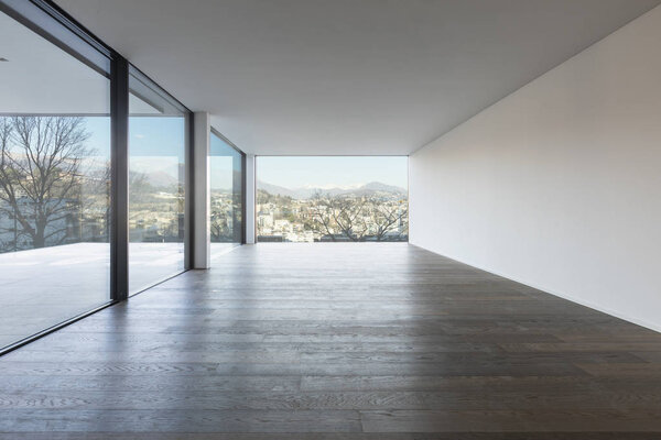 Modern white apartment with parquet floors and large windows overlooking the lake of Lugano. Nobody inside