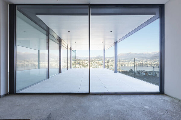 Luxury apartment overlooking the city under construction. Nobody inside, concrete floor