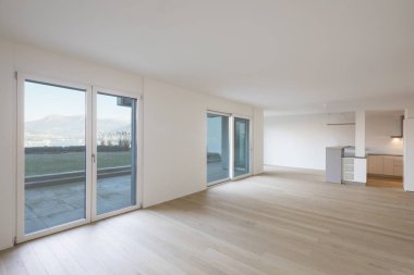 Beyaz duvarları, parke ve dağ manzaralı pencereler ile modern oturma odası. İçeride kimse yok