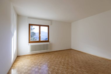 Sadece bir pencere ile boş bir odanın iç. Biz küçük bir radyatör ve ahşap zemin görebilirsiniz