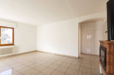 Geniş oturma odası şömine ve ışık ile yere döşenir. Sol duvarda bir pencere var ve yüzleşmek yerine yerleşik bir gardırop odalara yol açar kemerli bir kapı var.