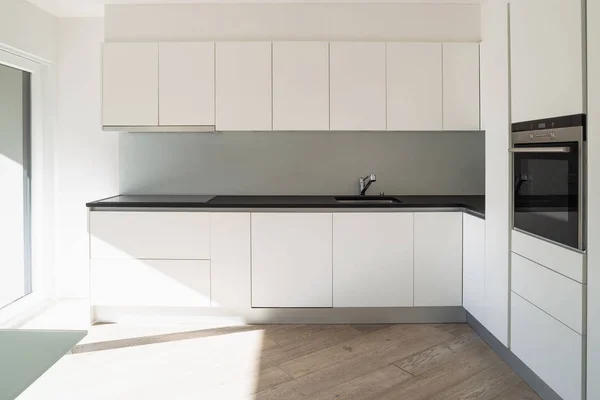 Vooraanzicht van de witte, minimalistische, moderne keuken — Stockfoto