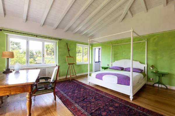 С кроватью с балдахином и зелеными одеялами — стоковое фото