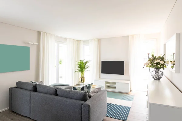 Вітальня з сірим диваном. Сучасна кімната і білі стіни — стокове фото