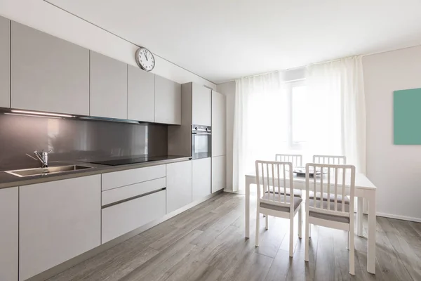 Moderne grijze keuken met witte stoel en tafel — Stockfoto