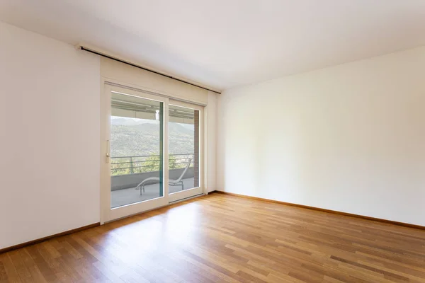 卧室有白色墙壁和镶木地板。带湖景的窗口. — 图库照片