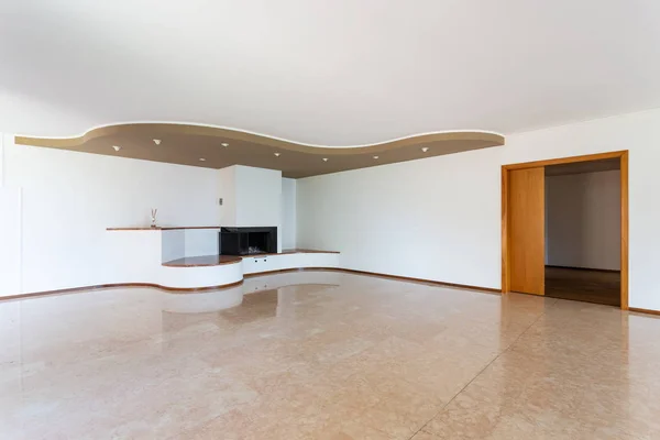 Empty living room with large fireplace and white walls — Stock Photo, Image