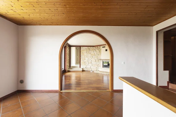 Prázdný obývací pokoj s parketami, krbem a skálou na stěnách — Stock fotografie