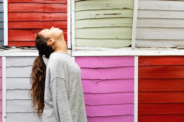 Profilo ritratto di una ragazza con recinzione colorata dietro — Foto Stock