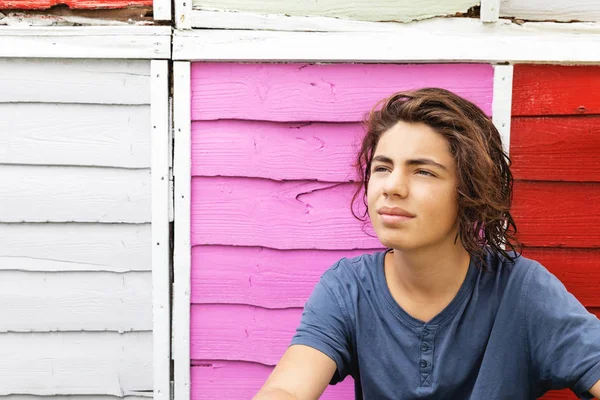 Porträt eines jungen Mannes mit farbigem Zaun dahinter — Stockfoto