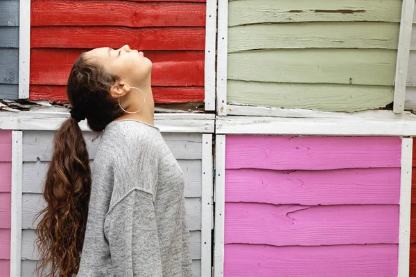 Profilo ritratto di una ragazza con recinzione colorata dietro — Foto Stock