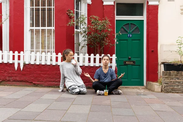 Un par de niños sentados fuera de casa con batido . — Foto de Stock