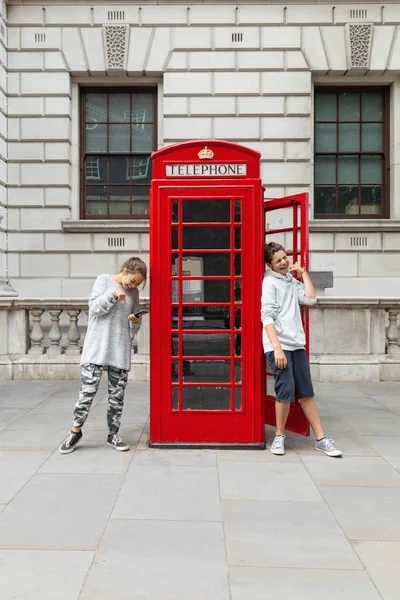 Two boys and a telephone box in London — Stock Photo, Image