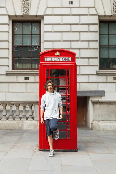 El chico está junto a una cabina telefónica — Foto de Stock