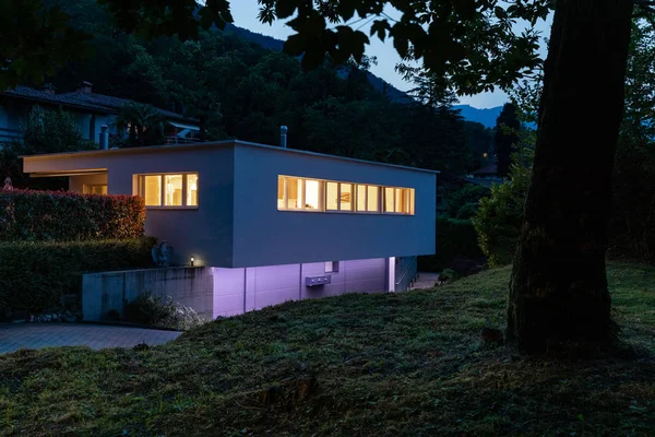 紫色の照明付きの家の外観。夜の画像 — ストック写真