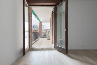 Beyaz duvarları olan büyük boş oda. Parke