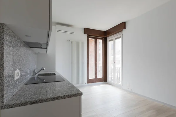 Grote lege kamer met witte muren en moderne keuken. — Stockfoto