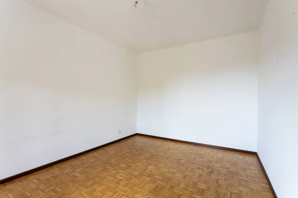 모든 흰색 벽과 쪽모이 세공 마루 바닥이있는 빈 방 — 스톡 사진