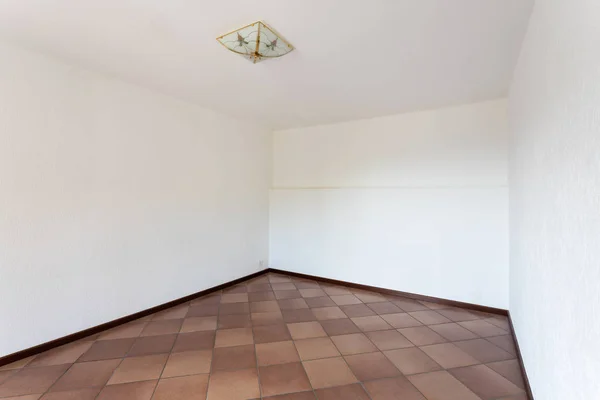 Chambre vide avec murs blancs et sol en terre cuite — Photo
