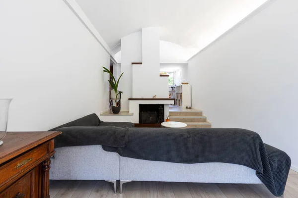 Grand salon avec grand canapé couvert et plafond voûté — Photo