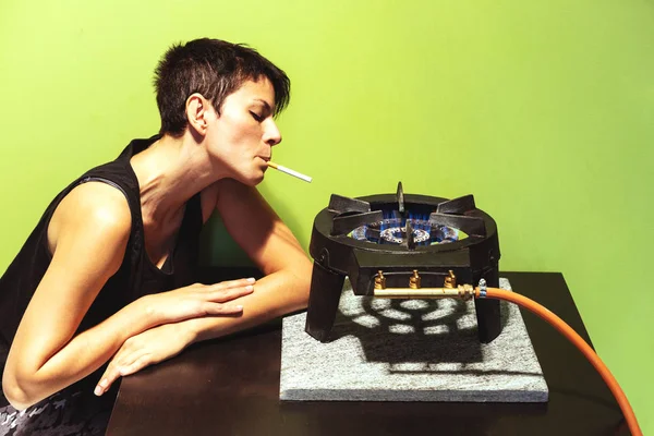 Jovem com tanque preto top luzes cigarro com fogão a gás — Fotografia de Stock