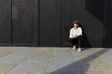 Genç çocuk spor ayakkabıları ile yere eğildi