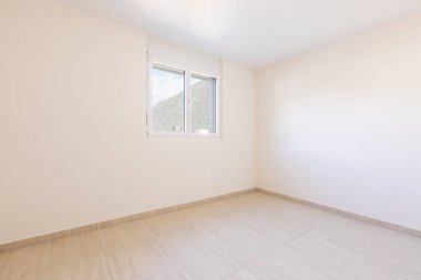 Beyaz duvarları ve traverti döşemeleri olan boş bir oda.