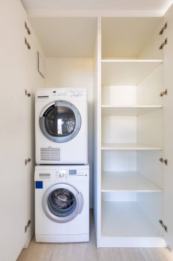 Beyaz bir dolapta çamaşır makinesi ve kurutma makinesinin ön görüntüsü 